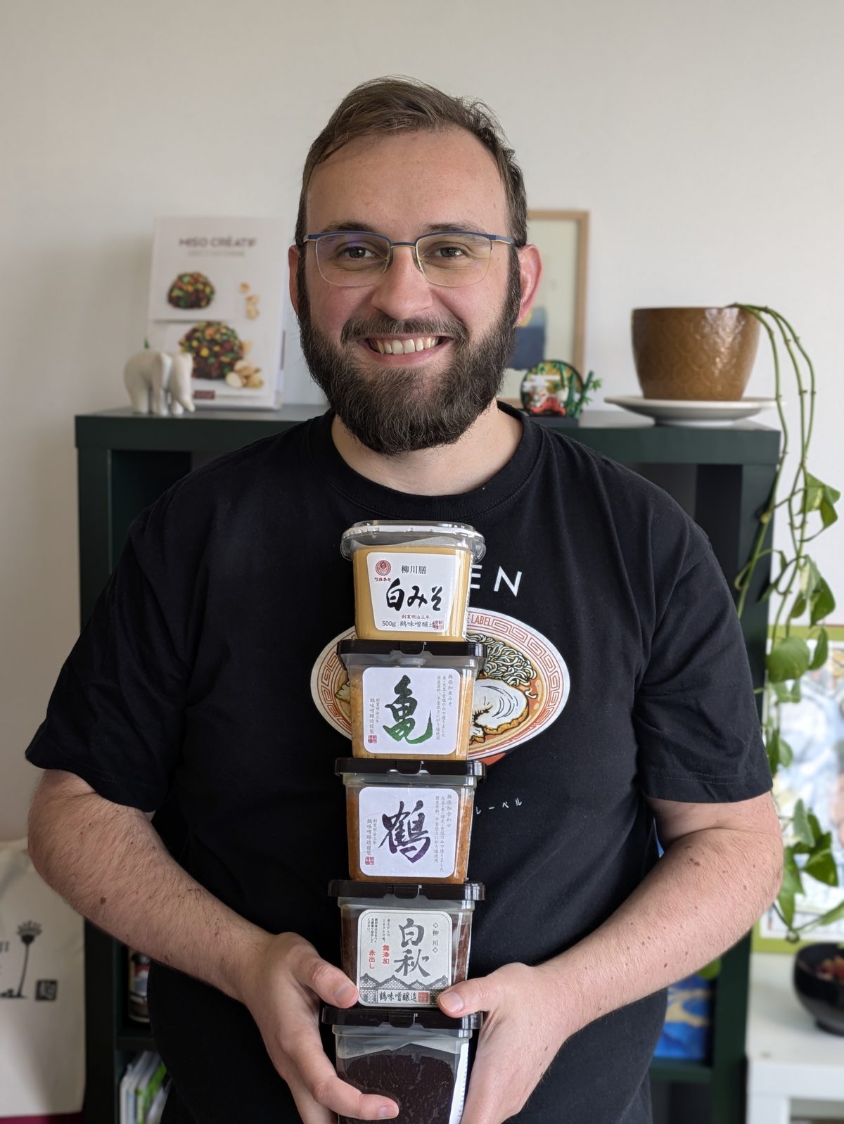 Alexandre, fondateur de Kojité, tenant une pile de pots de miso